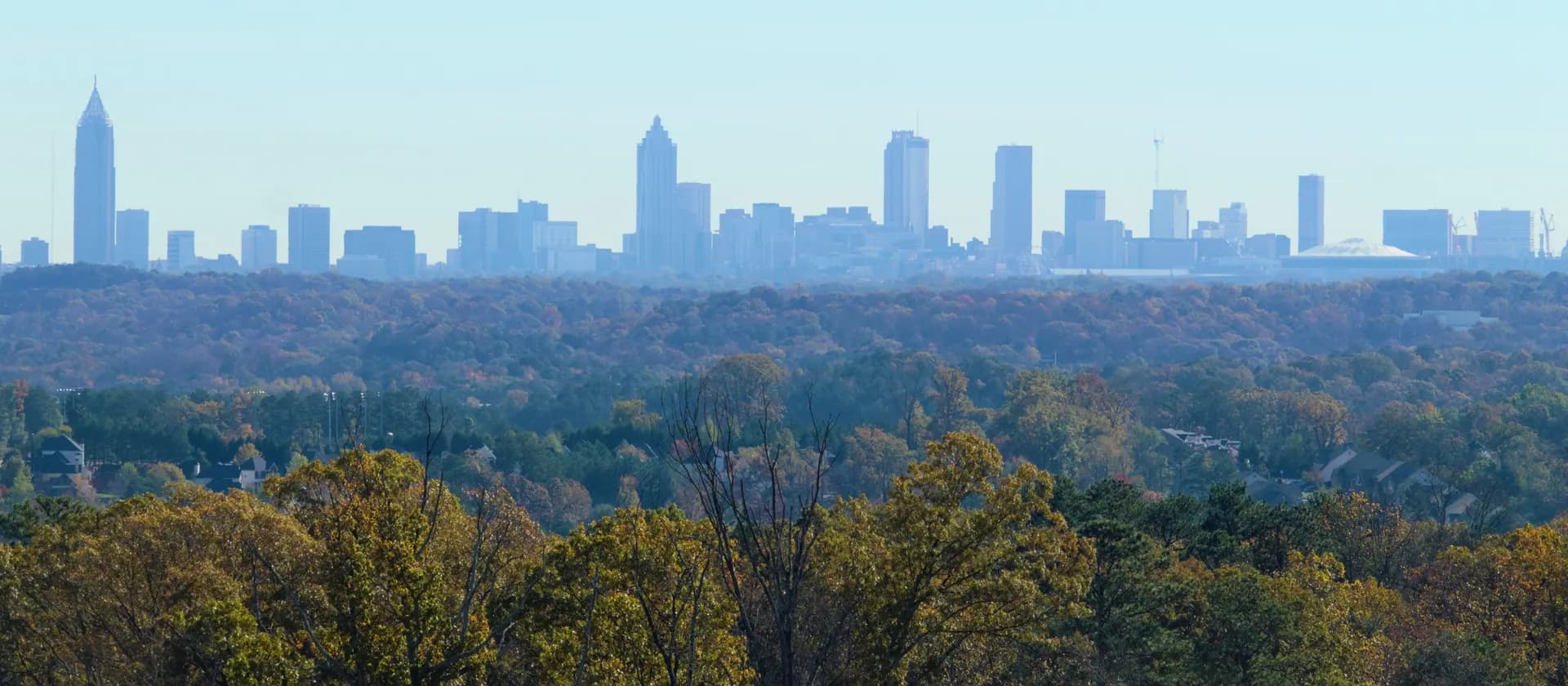 Stock photo: the downtown Atlanta skyline in the distance, seen over autumn treetops.
