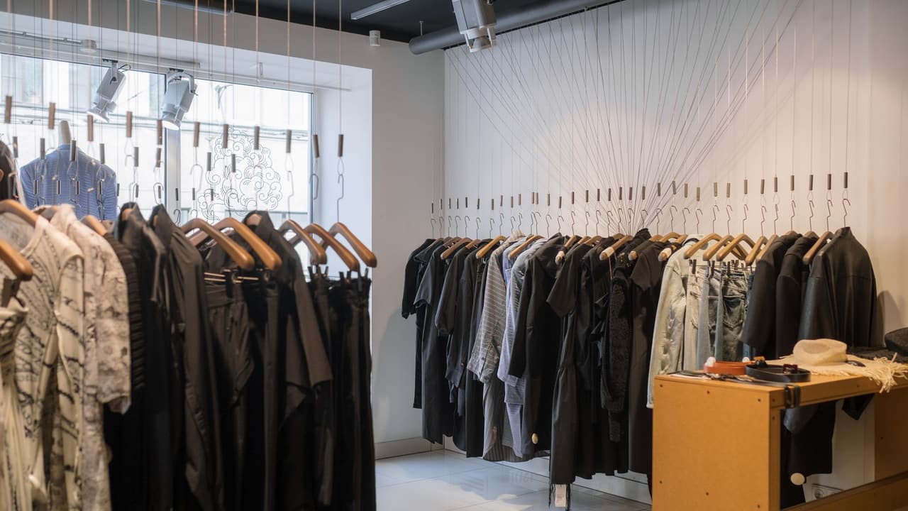 Stock photo: clothes hanging on racks in a small boutique.