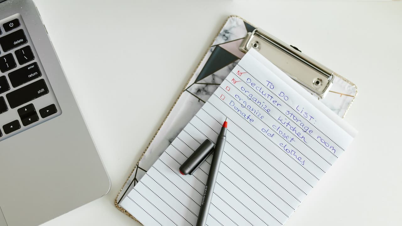 Stock photo: a handwritten checklist on a clipboard next to a laptop.
