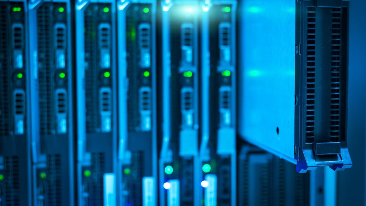 Stock photo: a rack of servers with glowing indicator lights in blue light.