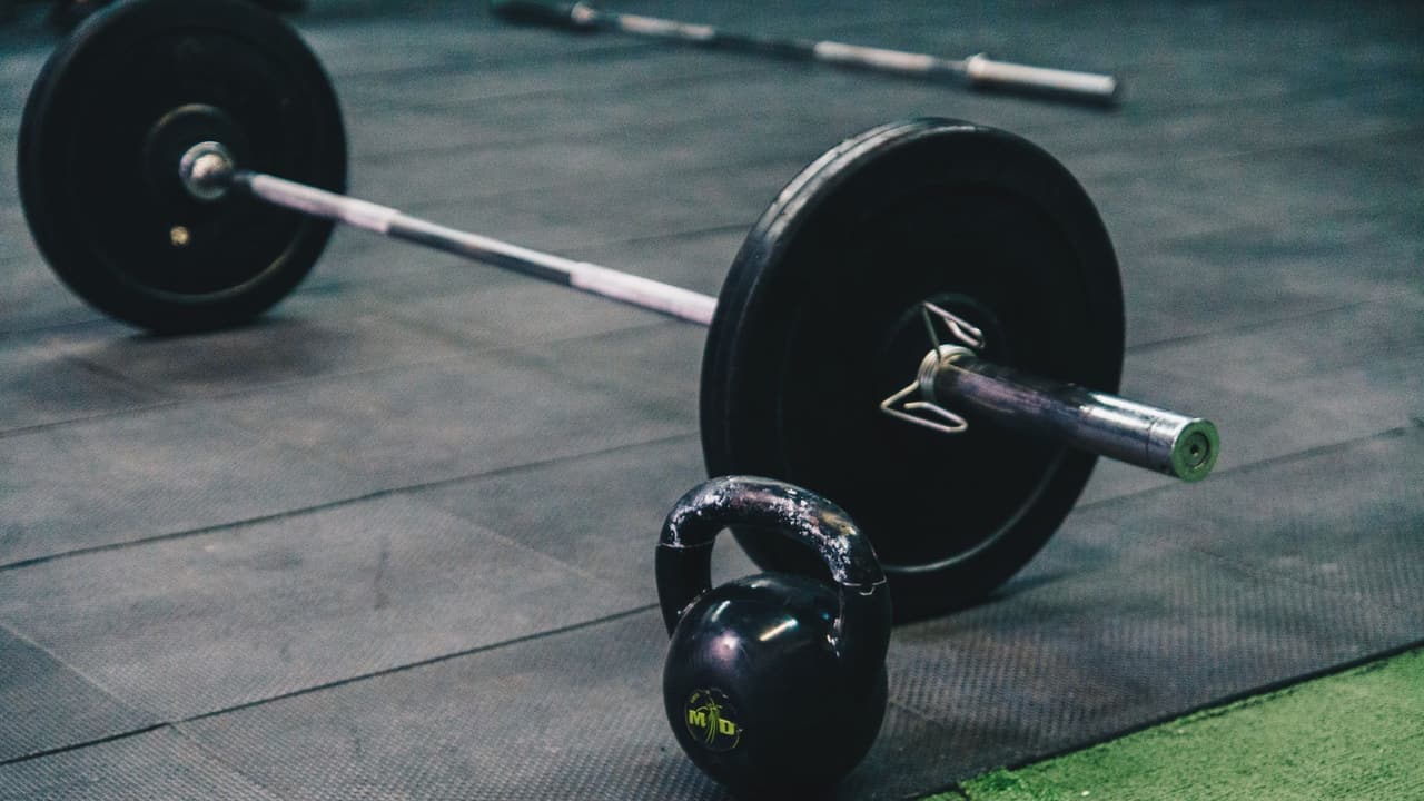 Stock photo: a barbell and a kettlebell on a rubber gym floor.