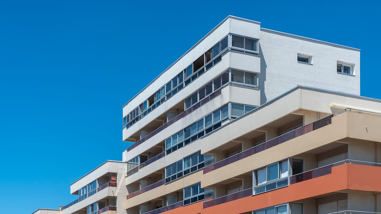 Stock photo: a contemporary multi-story apartment building against a blue sky.
