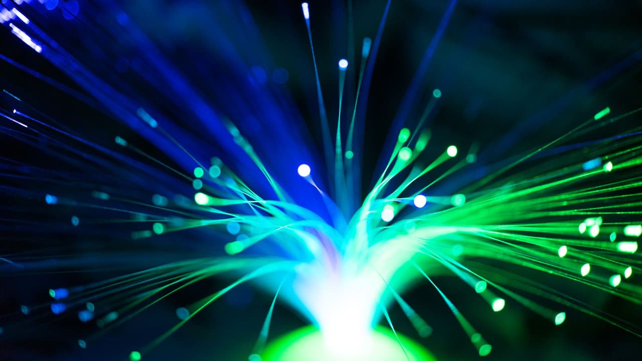 Stock photo: glowing strands of fiber optic light in blue and green.